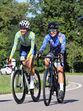 Lade das Bild in den Galerie-Viewer, Rennradfahrerinnen tragen Cocoa Hawaii Langarmtrikot und La Nucia buntes Hawaii Langarmtrikot mit Blumen