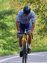 Lade das Bild in den Galerie-Viewer, Mann mit blumigen Hawaii Rennradtrikot und Rennradhose rosa blau