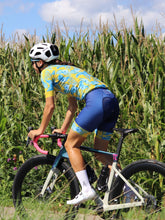 Lade das Bild in den Galerie-Viewer, Frau im bunten Cocoa Hawaii-Radtrikot mit Bibshorts
