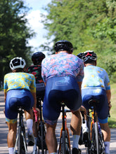 Lade das Bild in den Galerie-Viewer, Gruppe von Rennradfahrern mit bunten Radoutfits im Hawaii Style
