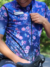 Lade das Bild in den Galerie-Viewer, Frau mit La Nucia Rennradweste Blumen Hawaii Style blau
